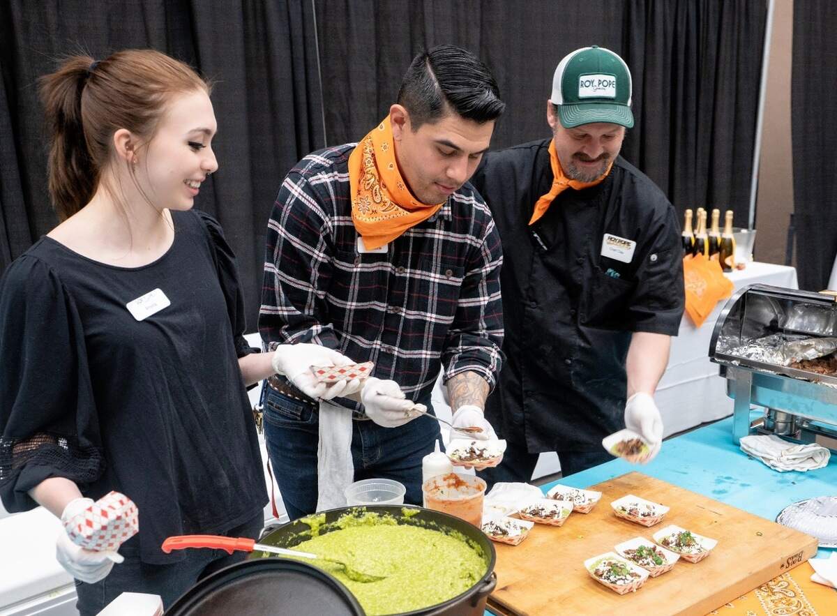 Amelia WIlson, Chris Reale and chef Clay Wilson serving for Roy Pope Grocery and the Paris Coffee Shop at the Bubbles & Bites champagne brunch before a Stock Show rodeo perfornance.