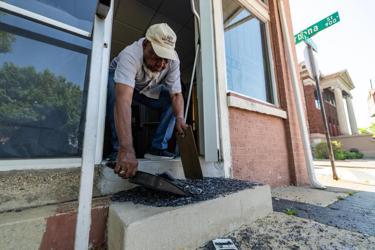James Mallard, a lifetime member of the NAACP Fort Worth Chapter, cleans up broken glass from one of the vandalized doors of the Fort Worth Tarrant County NAACP building in Fort Worth on Tuesday, April 15, 2025.