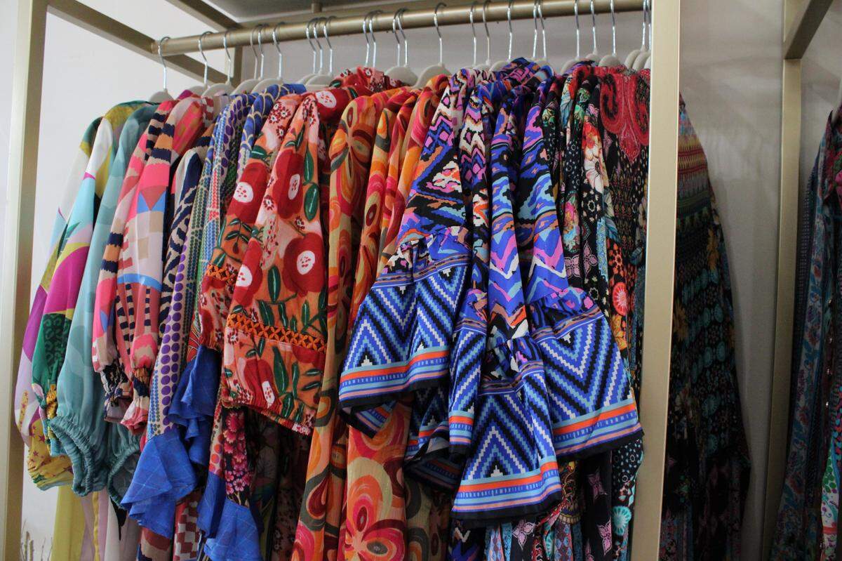 Colorful dresses hang on a rack at the Dos Femmes boutique.