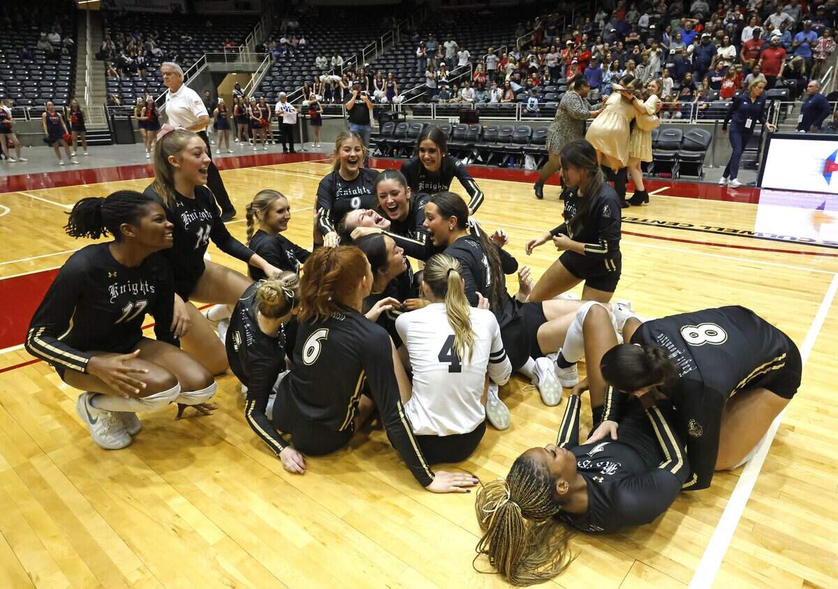 The Eagle Mountain Lady Knights storm the court as the coaches celebrate in the background after winning the UIL Class 4A Division II state volleyball championship game against Wimberley on Friday Nov. 21, 2025 at Curtis Culwell Center in Garland, Texas.