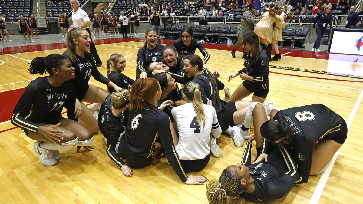 The Eagle Mountain Lady Knights storm the court as the coaches celebrate in the background after winning the Class 4A Division II state volleyball championship match against Wimberley on Friday at Curtis Culwell Center in Garland.