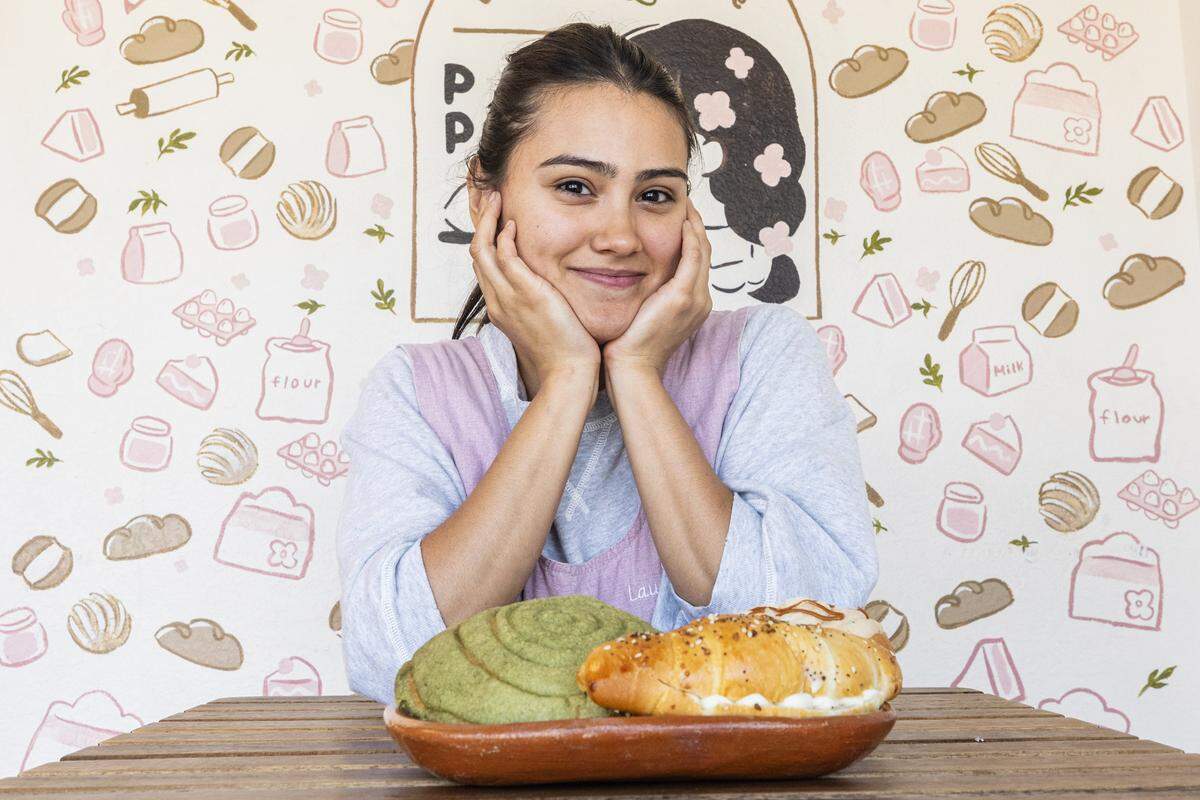 Laurita Molinar, owner of Pan Pan Bakery and Cafe, sits in front of a plate of pastries.