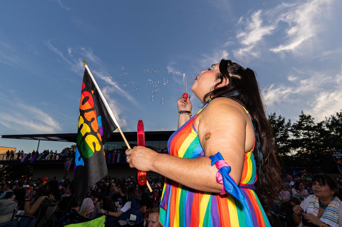 Cassandra Marquez blows bubbles while celebrating at the Arlington Pride event at Levitt Pavilion in Arlington on Saturday, June 8, 2024.