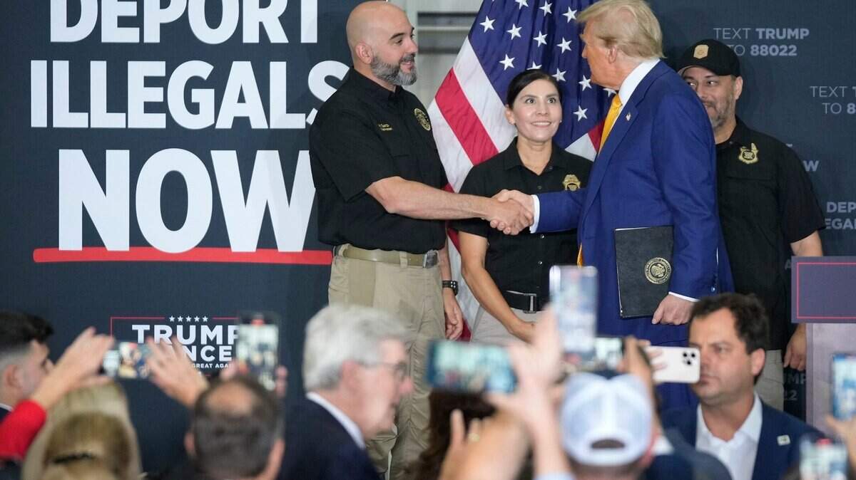 Former President Donald Trump greets a Border Patrol agent before speaking about border security at a rally at Million Air, a private airplane terminal at Austin-Bergstrom International Airport, Friday October 25, 2024.