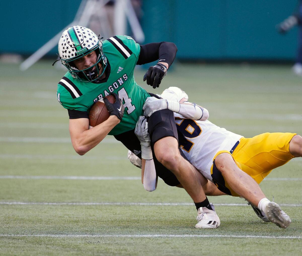 Carroll wide receiver Clayton Wayland (14) is brought down by Highland Park safety Jackson McGinley (46) in the first half of a UIL Conference 6A Division 2 region football playoff game at Choctaw Stadium in Arlington, Texas, Friday, Nov. 24, 2023.
