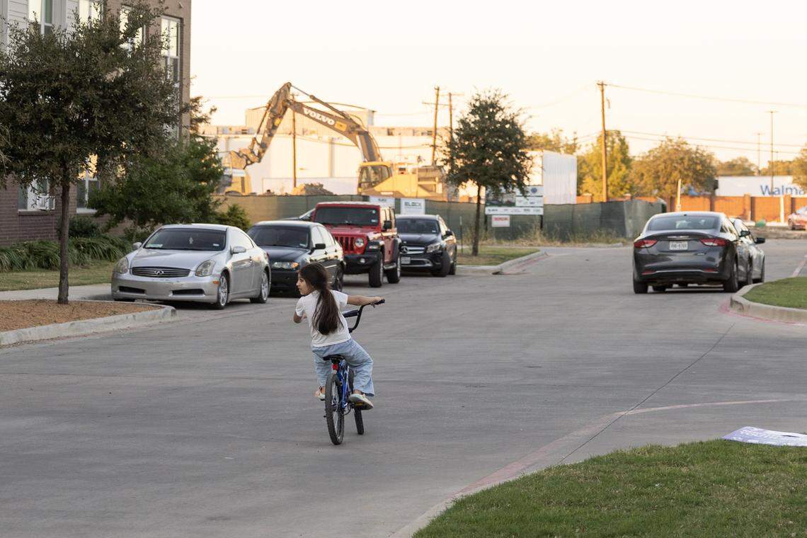 A child rides their bike through Columbia Renaissance Square in Fort Worth on Thursday, Nov, 13, 2025. The New Mitchell Boulevard neighborhood is a recipient of the 2026 Neighborhood Improvement Program. The program targets city funds to help neighborhoods struggling with public safety, poor streets, and residents struggling with poverty.