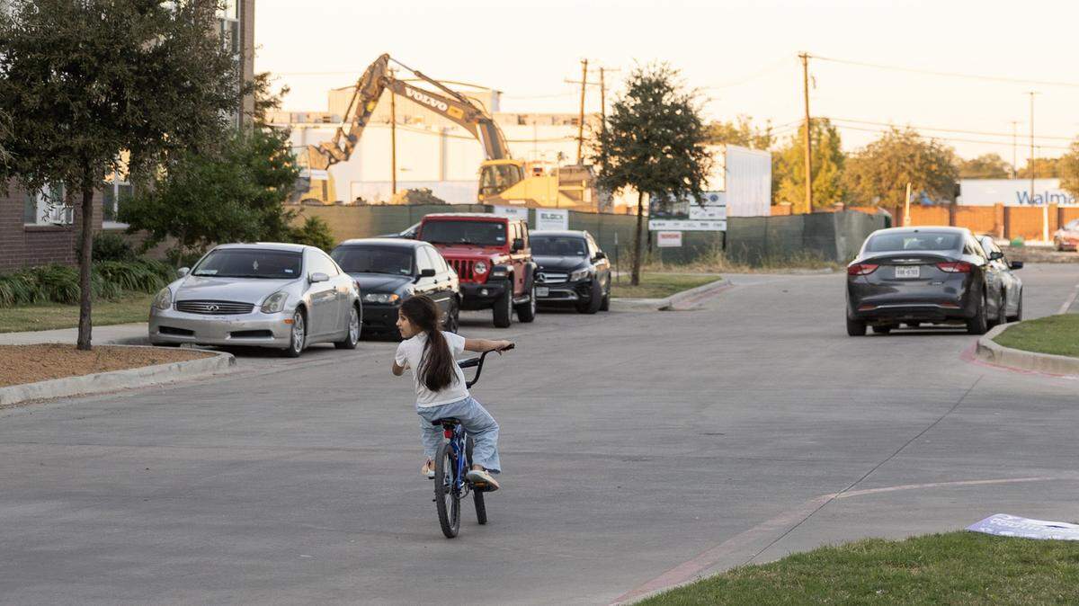 A child rides their bike through Columbia Renaissance Square in Fort Worth on Thursday, Nov, 13, 2025. The New Mitchell Boulevard neighborhood is a recipient of the 2026 Neighborhood Improvement Program. The program targets city funds to help neighborhoods struggling with public safety, poor streets, and residents struggling with poverty.
