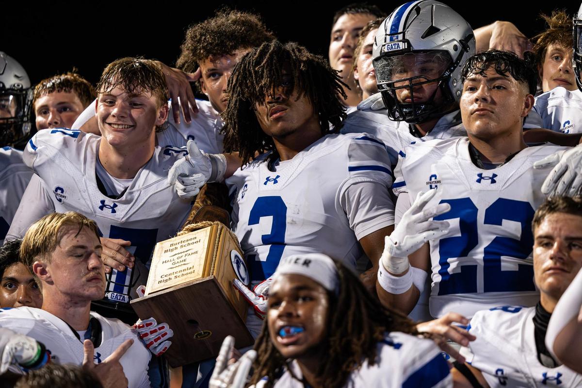 Burleson Centennial wide receiver Damien Long (3) holds the Boot Bowl trophy after his team won the 2024 Boot Bowl game against Burleson High School at BISD Stadium in Burleson on Friday, Aug. 30, 2024. The Spartans defeated the Elk 28-7 to take home the Boot Bowl trophy for the third year in a row.