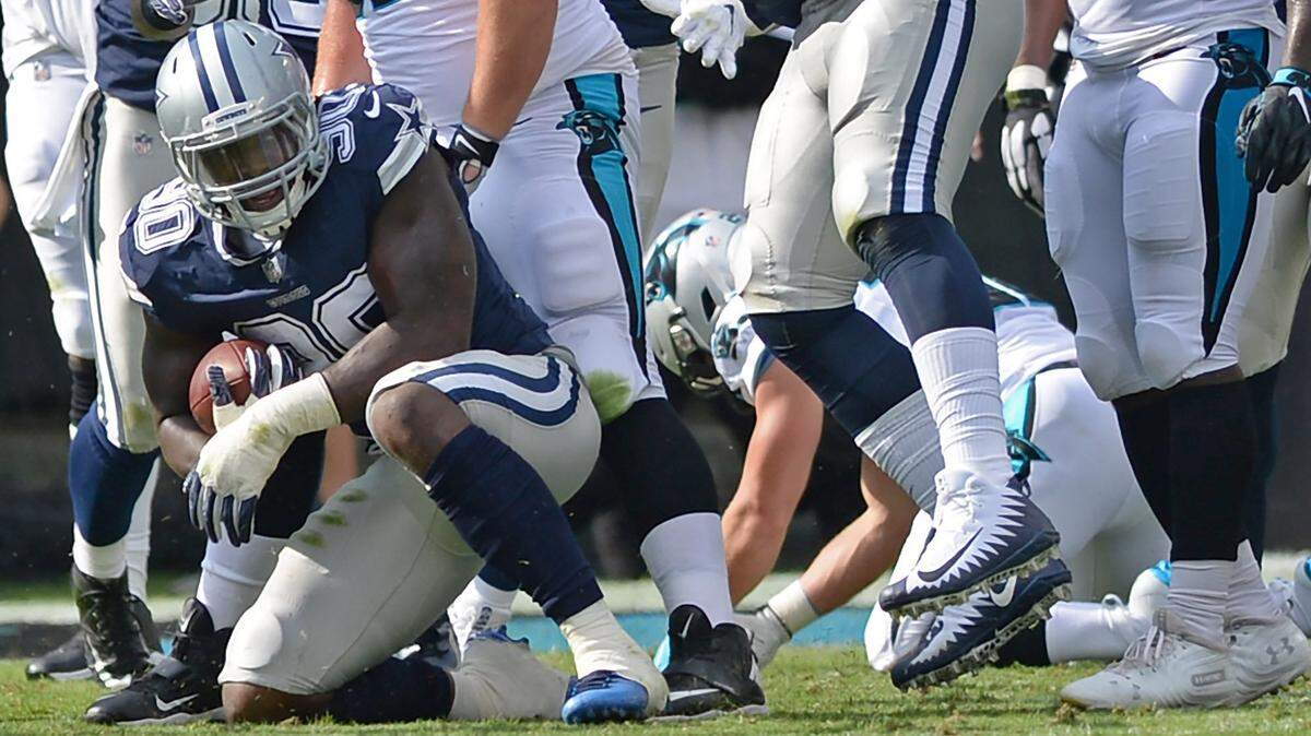 Cowboys defensive end DeMarcus Lawrence, left, recovers a fumble by Carolina Panthers running back Christian McCaffrey during first quarter action at Bank of America Stadium on September 9.