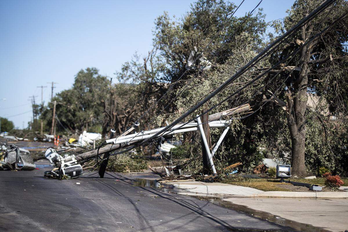 Utility poles lay in the street after a tornado Monday, Oct. 21, 2019, near Walnut Hill Lane in Northwest Dallas.