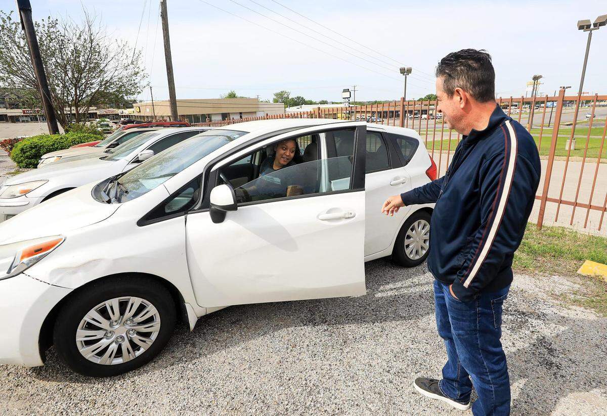 Wayne Harrison, rights, shows Jazmine Brooks 2014 Nissan Versa on his lot at Owl Own It Auto Sales last week.