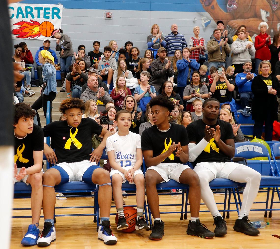 Carter Escobar, 9, waits on the bench with team mates to be introduced before a high school basketball game at Brewer High School in White Settlement, Texas, Friday, Feb. 14, 2020. Escobar suffers from a childhood cancer and also Long QT Syndrome which is a disorder of the hearts electrical activity. Playing basketball for the Brewer Bears was on his bucket list. (Special to the Star-Telegram Bob Booth)