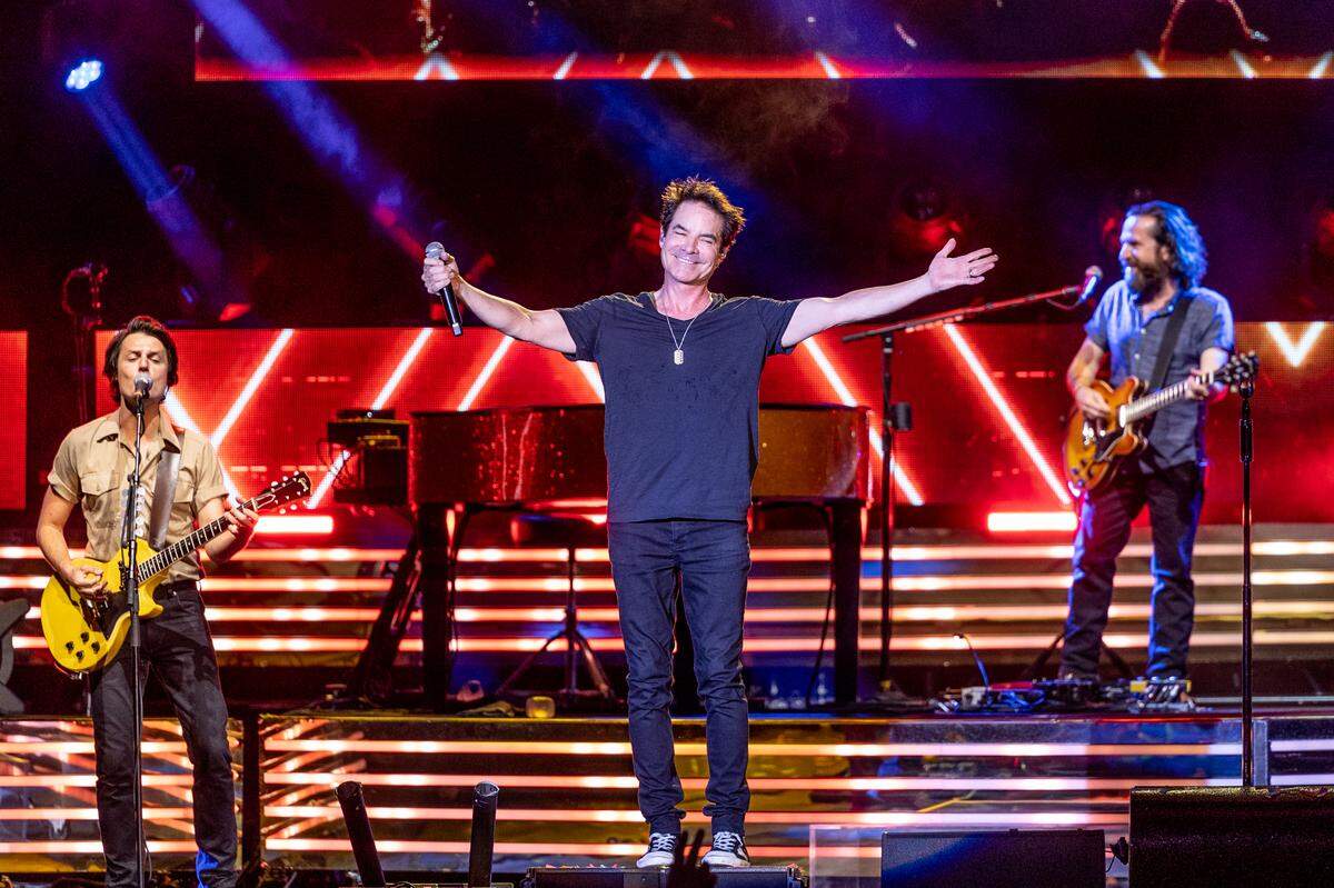 Train lead singer Pat Monahan, along with guitarist Taylor Locke, left, and Jerry Becker, right, plus bassist Hector Maldonado, drummer Matt Musty and backup singers Sakai Smith and Nikita Houston played for about an hour and a half in 100-degree heat Wednesday night at Dos Equis Pavilion in Dallas.