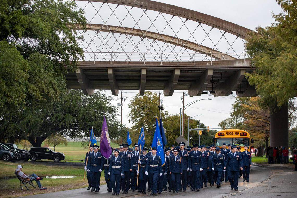 Air Force Junior ROTC cadets chant as they pass under a bridge during the Veterans Day Parade winding through Fort Worth on Friday, Nov. 11, 2022. Despite rain, hundreds of participants marched down North Forest Park Boulevard, waving American flags and signing a medley of military songs.
