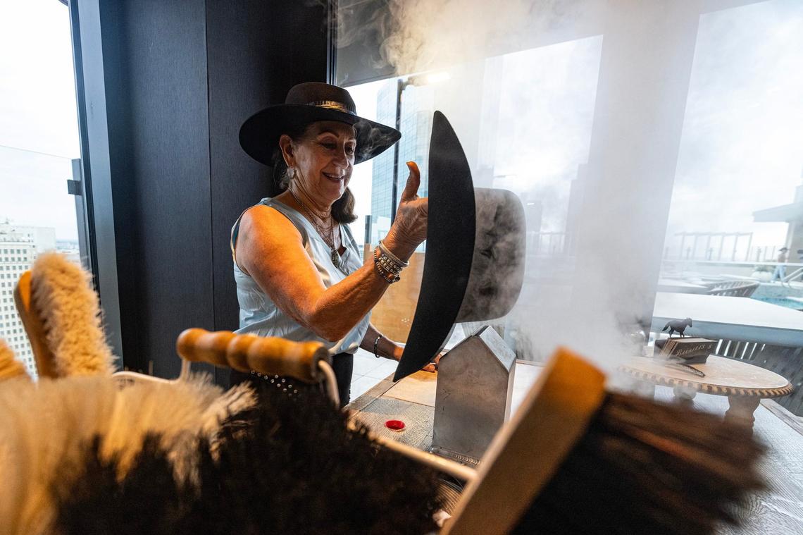 Professional hat shaper Claudia Ferretti steams a new hat for a customer at Deco’s Custom Hat Shop on the 24th floor of the Deco 969 high rise apartment building in downtown Fort Worth on Wednesday, July 17, 2024.
