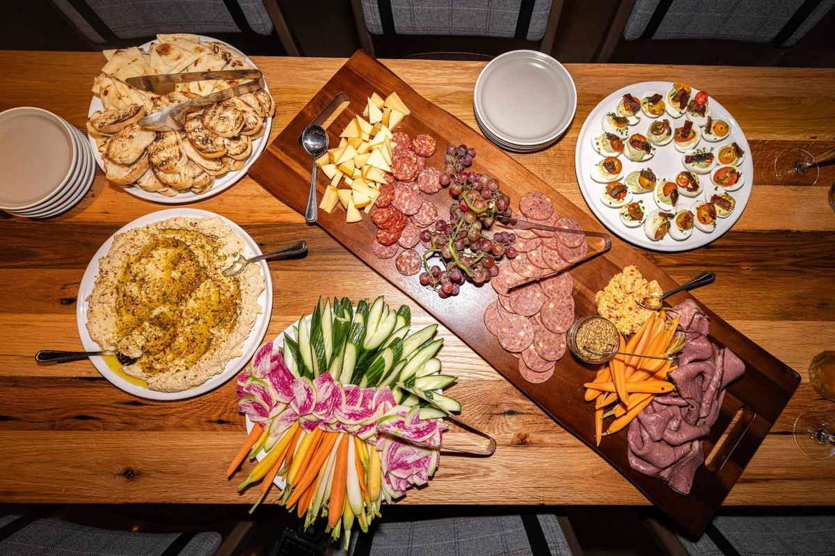 The roasted garlic hummus, the butcher board, and deviled eggs are spread on the table at from the new Whiskey Cake restaurant in Alliance.
