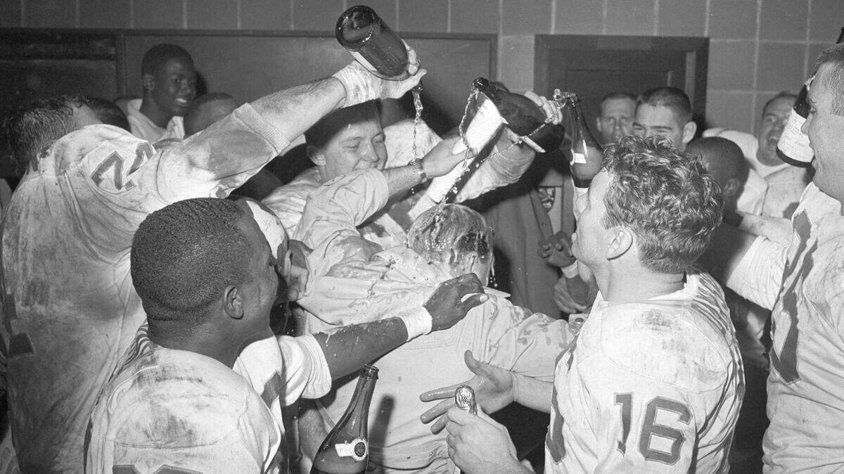Len Dawson, right No. 16, and his teammates give Dallas Texan Coach Hank Stram a champagne shower after they beat the Houston Oilers to win the 1962 AFL title.