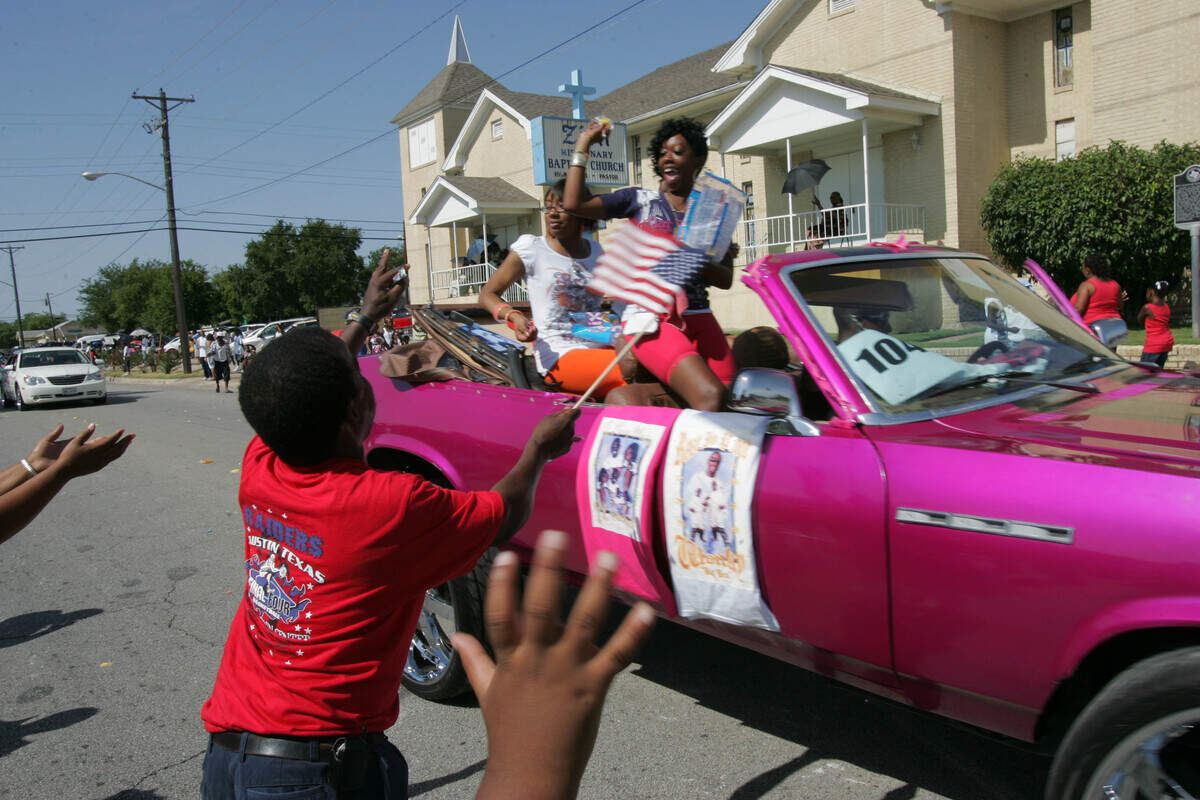 Tommy Johnson waves his flag and tries to catch some flying candy at the W.H. Wilburn Lake Como Day Parade on July 4, 2008, as it passes Zion Missionary Baptist Church.