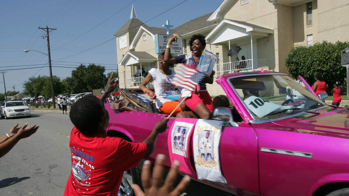 Tommy Johnson waves his flag and tries to catch some flying candy at the W.H. Wilburn Lake Como Day Parade on July 4, 2008.