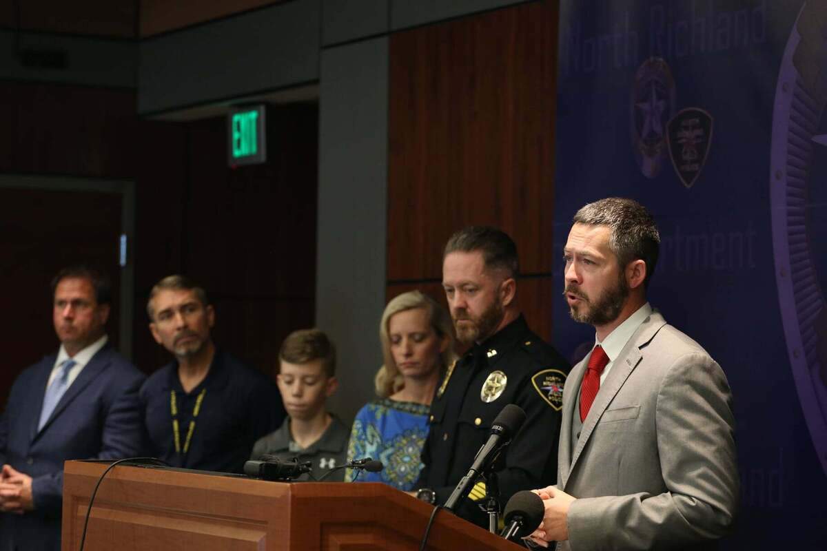 North Richland Hills Police Detective Erik Whitlock describes the investigation leading to closing a 19-year-old cold case involving seven bank robberies and an officer who was shot by the suspect. The wounded officer, Jeff Garner, now a captain, is standing to Whitlock’s right.