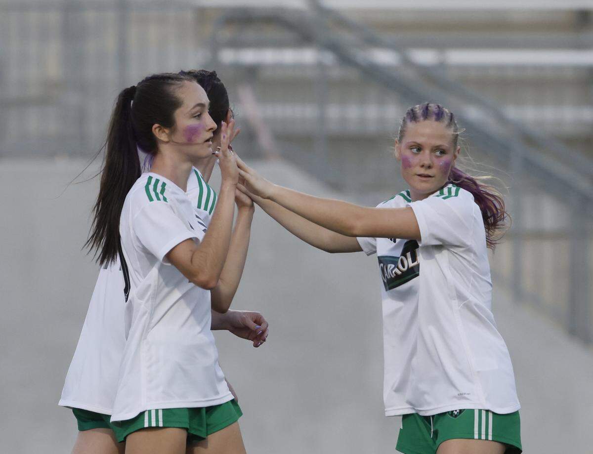 Southlake Carroll defender Ava Sexton (14) congratulates midfielder Maura Hayes (20) after she scored during the second half of a UIL bi-district round soccer playoff game at Crowley ISD Multi-Purpose Stadium in Fort Worth, Texas, Friday, March, 20, 2026.