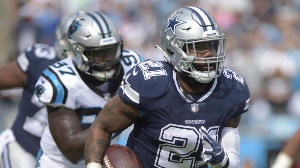 Cowboys’ Ezekiel Elliott runs past Carolina Panthers’ Mario Addison during the first half on Sunday. Elliott finished with 69 yards on 15 carries, tied for the third-fewest rushes by him in a game.