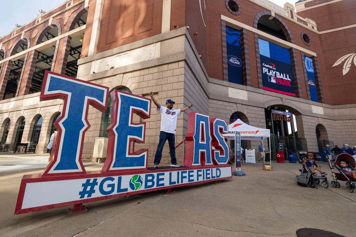 Carrolton resident Candelario Solis takes a picture at the Texas sign outside of the 2024 MLB All-Star Village at Choctaw Stadium in Arlington on Saturday, July 13, 2024.