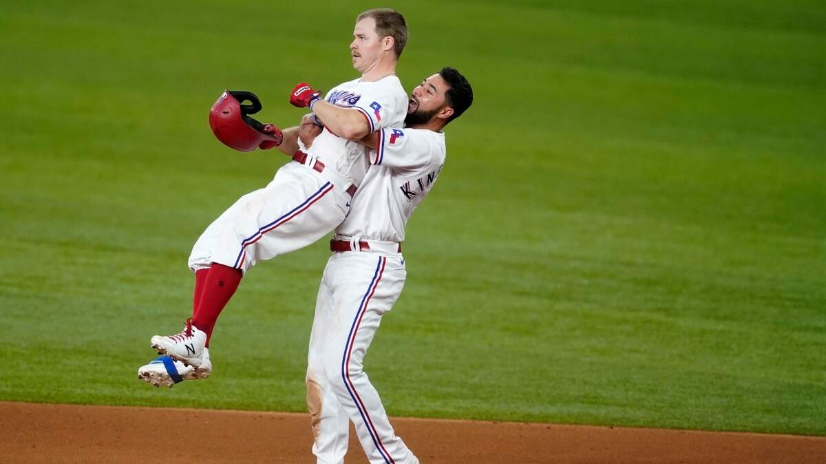 Texas Rangers’ Brock Holt, left, and Isiah Kiner-Falefa, right, celebrate Holt’s walk-off single in the 11th inning against the San Francisco Giants Wednesday afternoon at Globe Life Field in Arlington.