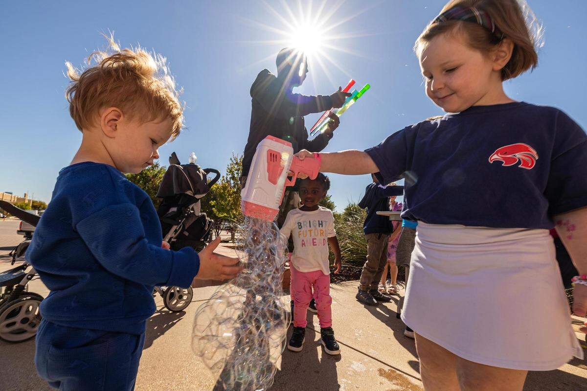 Siblings August, 1, and Eloise, 4, plays with bubbles during the Annular Solar Eclipse event at the Fort Worth Museum of Science & History on Saturday, Oct. 14, 2023.