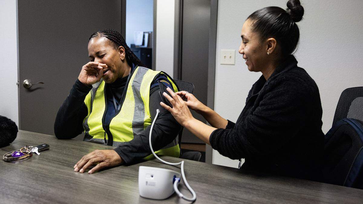 Ramonica Tarrant, left, reacts to her good blood pressure reading taken by nursing student Mychel Menchaca, right, as part of the Wellness on Wheels program at HIM Food Bank in Mansfield on Wednesday, Dec. 3, 2025.