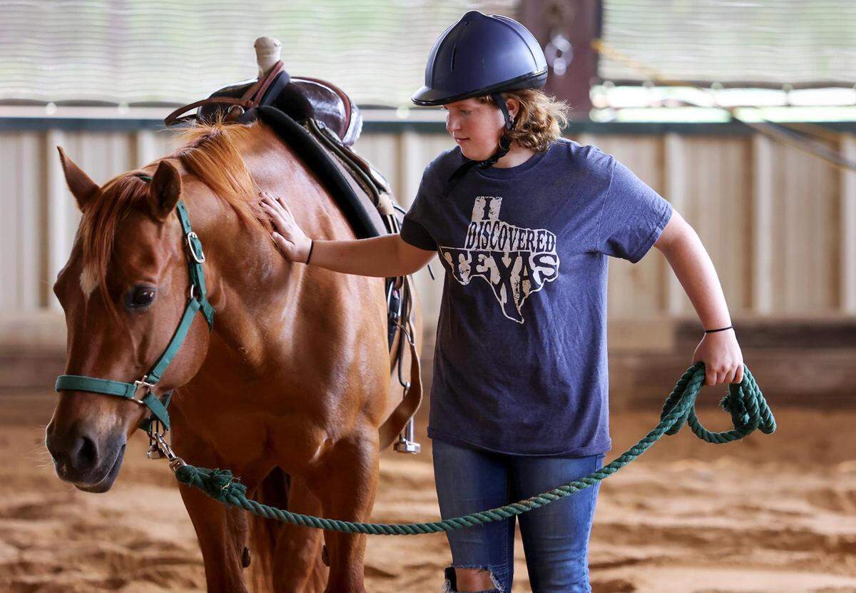 Gracie Alansard leads JJ during her session at Wings of Hope Equitherapy in Cleburne. Wings of Hope provides equine-assisted therapy to people with various needs.