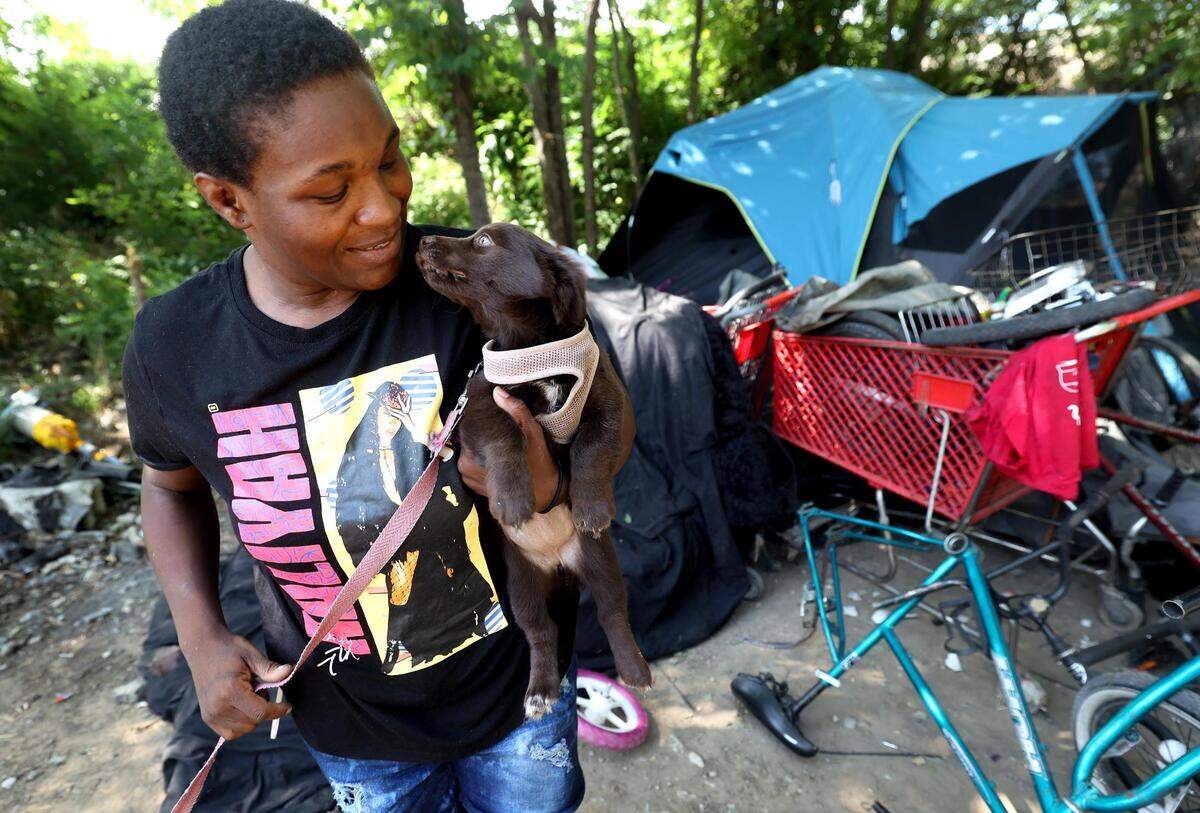 Maxine Owens gives kisses to her new puppy on Thursday, July 6, 2023. Owens learned that day she was matched with an assistance program that helped pay her rent for at least three months, allowing her to escape Texas’ dangerous heat.