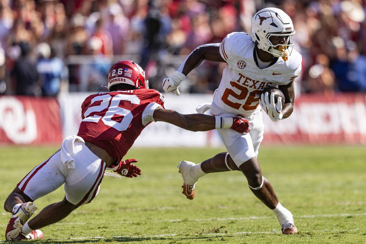 Texas running Quintrevion Wisner (26) escapes a tackle from Oklahoma defensive back Kani Walker (26) for a gain in the first half of an NCAA football game at the Cotton Bowl in Dallas on Saturday, Oct. 12, 2024.