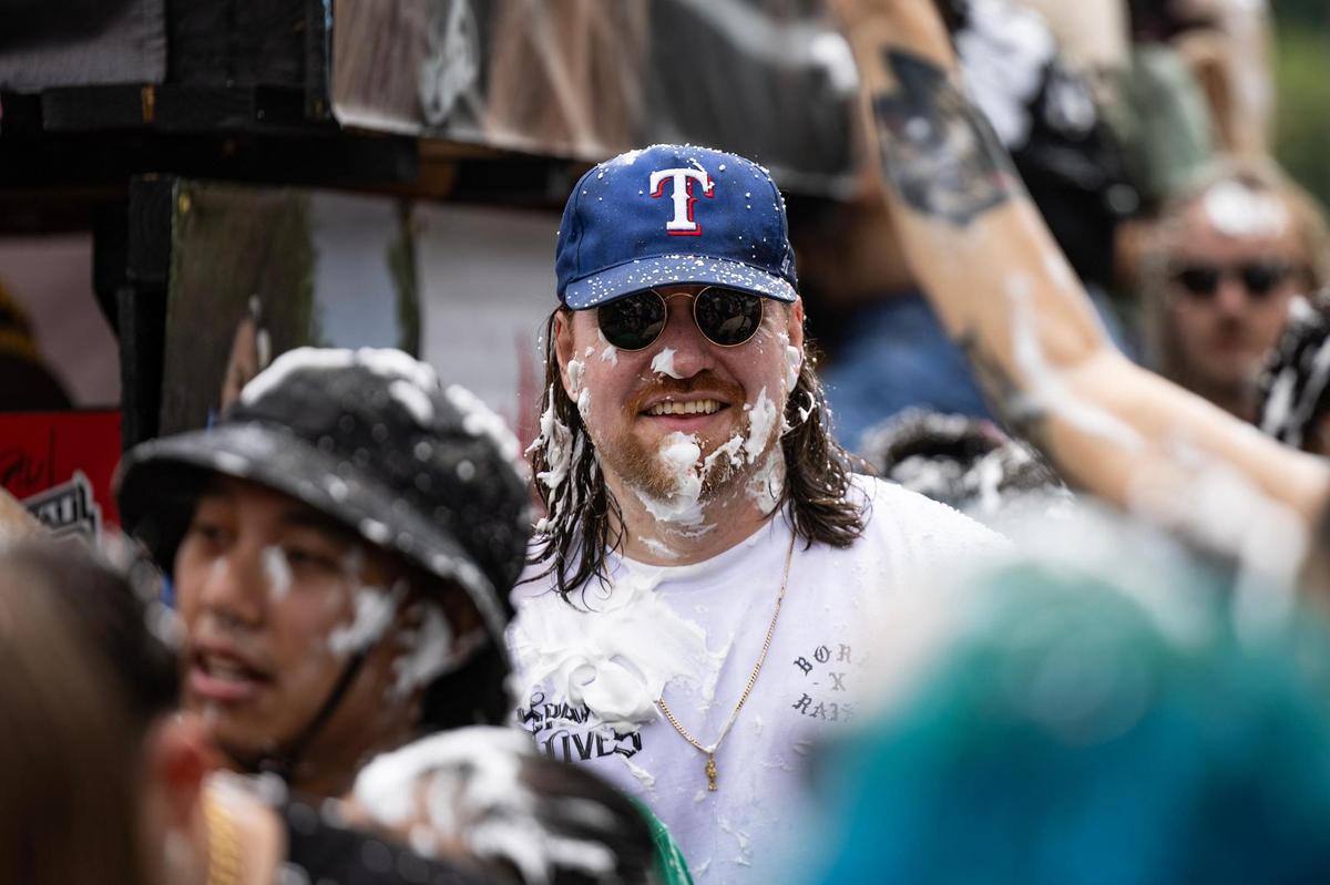 A festival attendee wears a Texas Rangers hat while covered in shaving cream during the Lao New Year parade on the third day of the Lao New Year festival at Wat Lao Thepnimith Temple in Saginaw on Sunday, April 27, 2025.
