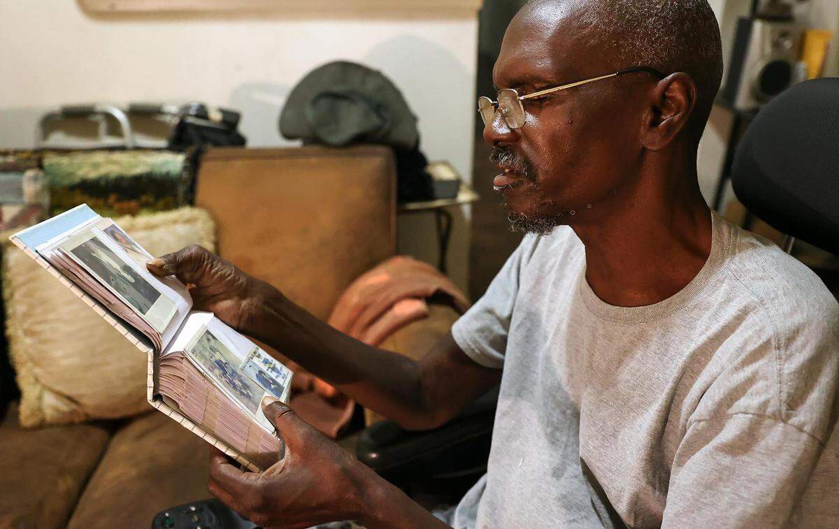 Willie Miller looks through photo albums for photographs of his son, Robert Miller, in his Fort Worth home in July. Miller said his son was never diagnosed with sickle cell anemia, the cause of death listed on his autopsy report.