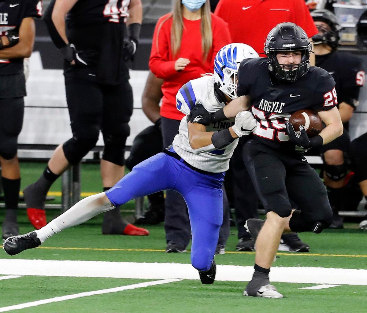 Argyle running back Braden Baker (29) is tackled by Lindale’s Corey Sanders (2) after a 39 yard run during a Conference 4A Division 1 State Championship football game at AT&T Stadium in Arlington, Texas, Friday, Dec. 18, 2020. Argyle defeated Lindale 49-21. (Special to the Star-Telegram Bob Booth)
