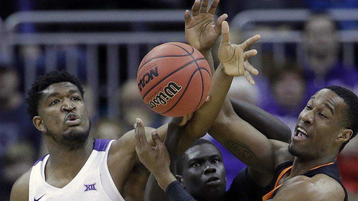 TCU’s Kevin Samuel (21) competes for a rebound against Oklahoma State’s Cameron McGriff, right, and Yor Anei during the first half of an NCAA college basketball game in the Big 12 men’s tournament Wednesday, March 13, 2019, in Kansas City, Mo. (AP Photo/Charlie Riedel)