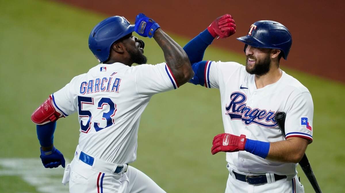 Texas Rangers manager Chris Woodward was proud of Adolis Garcia, left, legging out a double in the All-Star Game on Tuesday. He was also happy to see pitcher Kyle Gibson throw only 12 pitches in a scoreless inning. And he thought Joey Gallo, right, was wronged during Monday’s Home Run Derby.