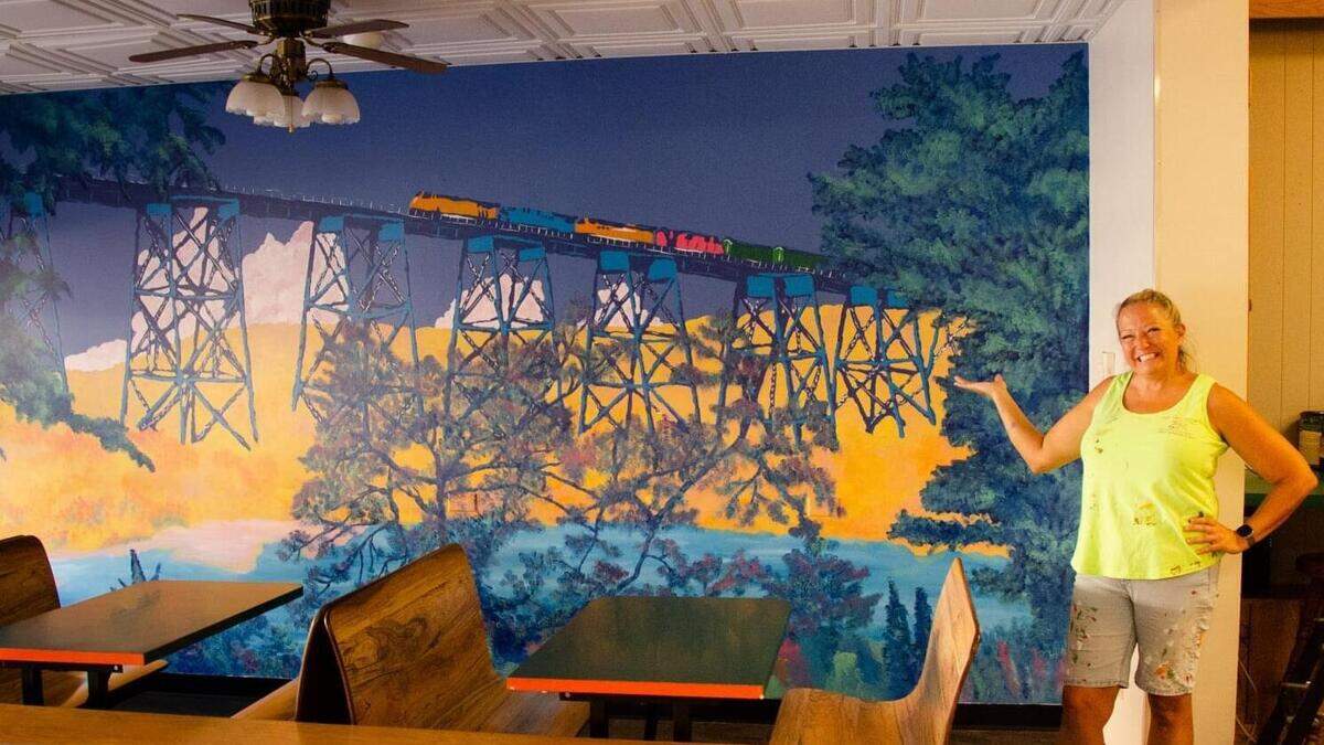 Sheri Lopez, owner of That’s Flippin’ Smart Art, shows off a bridge mural she painted.