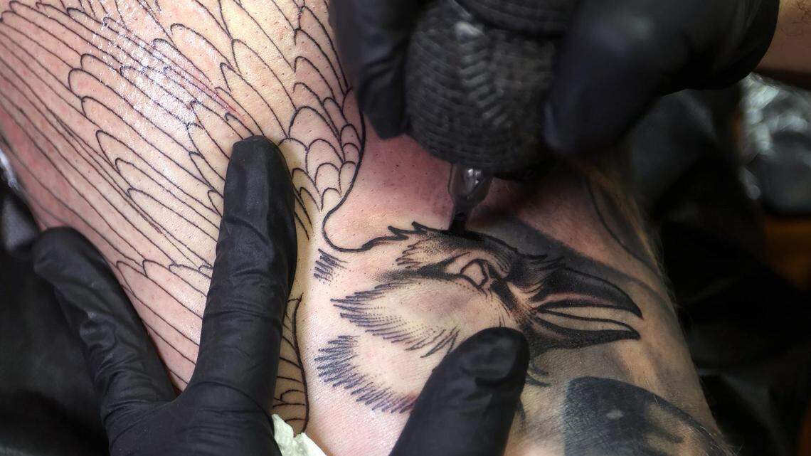 Scott Prather tattoos a crow on Xander Fallek at his private studio in Fort Worth on March 27, 2023.