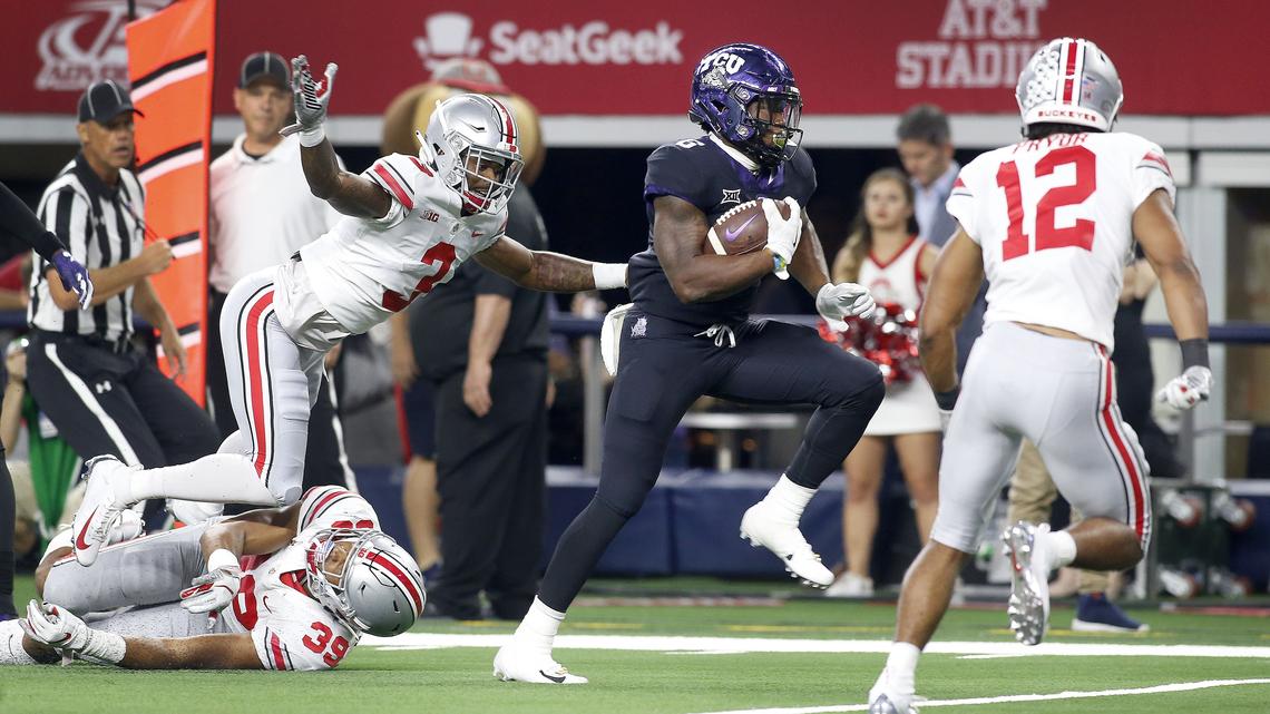 TCU Horned Frogs running back Darius Anderson (6) runs past Ohio State Buckeyes Damon Amette Jr. (3) and  linebacker Malik Harrison (39) during the first half of a college football game at AT&T Stadium in Arlington, Texas on Saturday, Sept. 15, 2018.