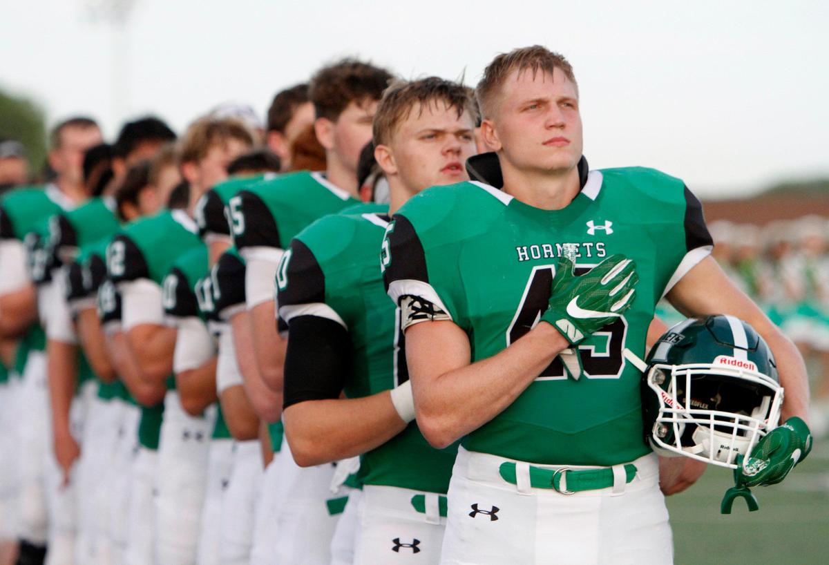 Azle Hornets, including Jacob Edwardes (45) line up for the anthem before kickoff. The Grapevine Mustangs played the Axle Hornets on the opening night of Friday night football at Hornet Field in Azle, August 30, 2019.