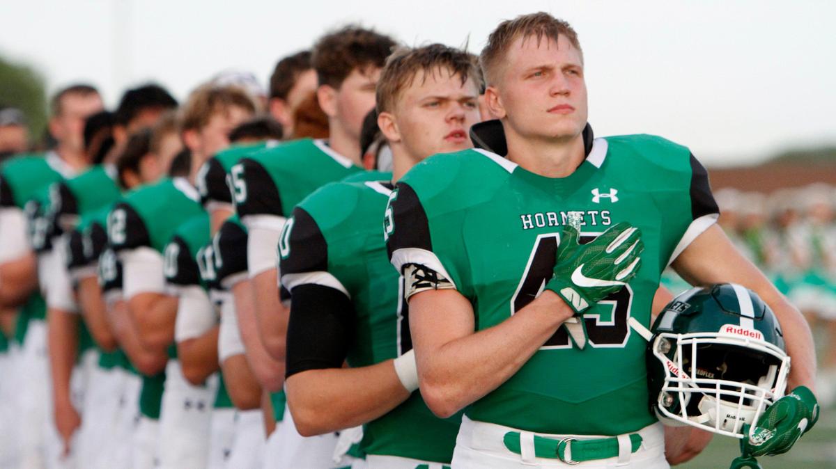 Azle Hornets, including Jacob Edwardes (45) line up for the anthem before kickoff. The Grapevine Mustangs played the Axle Hornets on the opening night of Friday night football at Hornet Field in Azle, August 30, 2019.