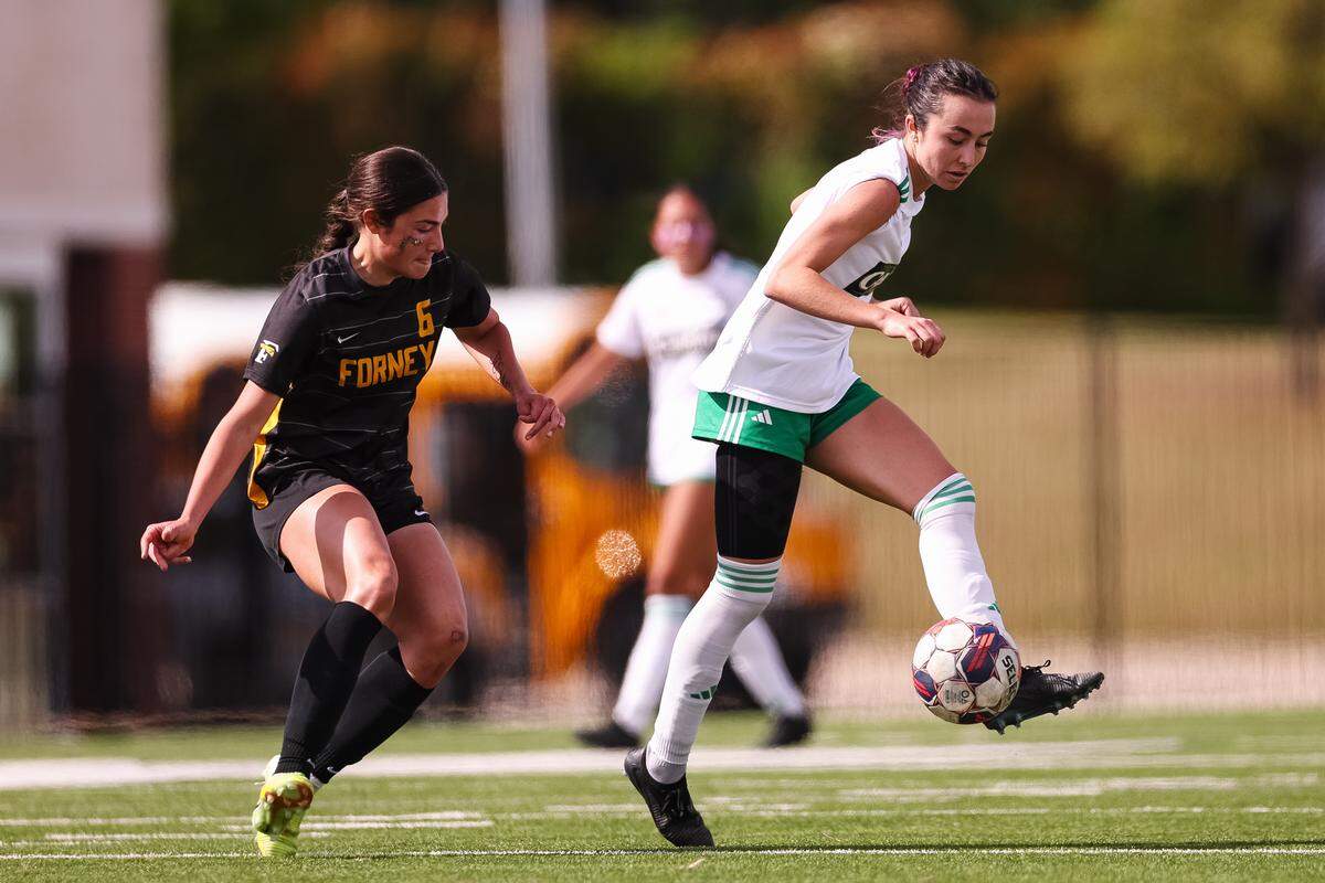 Southlake Carroll defender Berklee McCombs (21) passes the ball as a Forney defender closes in on the ball in a UIL Class 6A Division 2 girls soccer state semifinal on Saturday, April 4, 2026, at Memorial Stadium in Mesquite, Texas.