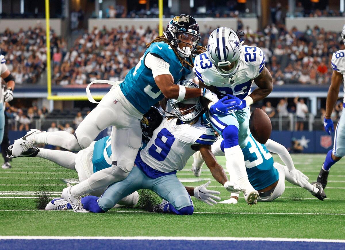 Dallas Cowboys running back Rico Dowdle fumbles the ball after receiving pressure from Jacksonville Jaguars cornerback Gregory Junior during a preseason game on Saturday, August 12, 2023, at AT&T Stadium in Arlington.