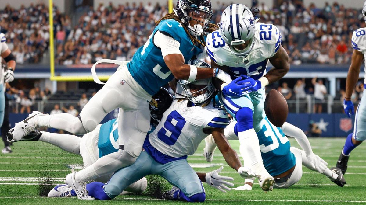 Dallas Cowboys running back Rico Dowdle (23) fumbles the ball after receiving pressure from Jacksonville Jaguars cornerback Gregory Junior during a preseason game on Saturday, August 12, 2023, at AT&T Stadium in Arlington.