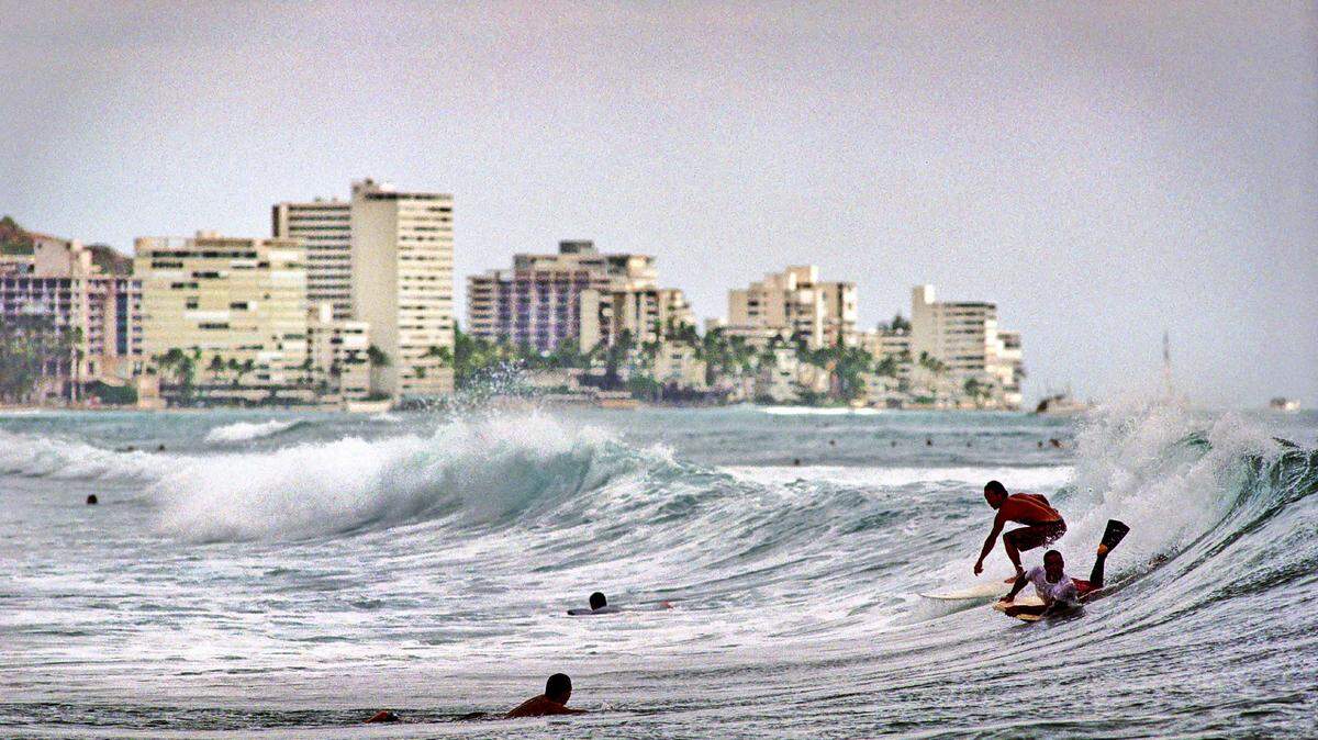A non-stop flight from Dallas to Honolulu takes nearly 8 hours. File photo -- surfers riding breaks off of Ala Moana Beach Park with Waikiki in the background.