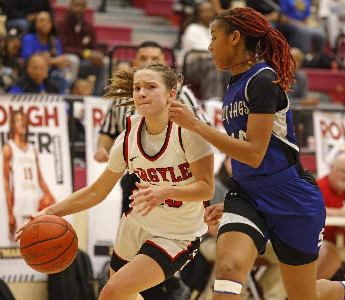 Argyle guard Lexi Ehrhardt (20) drives hard to the net defended by Mansfield Summit guard Kyleigh Smith (10) during the second half of a UIL Class 5A DII girls playoff basketball game at Saginaw High School in Saginaw, Texas, Thursday Feb. 19, 2026.