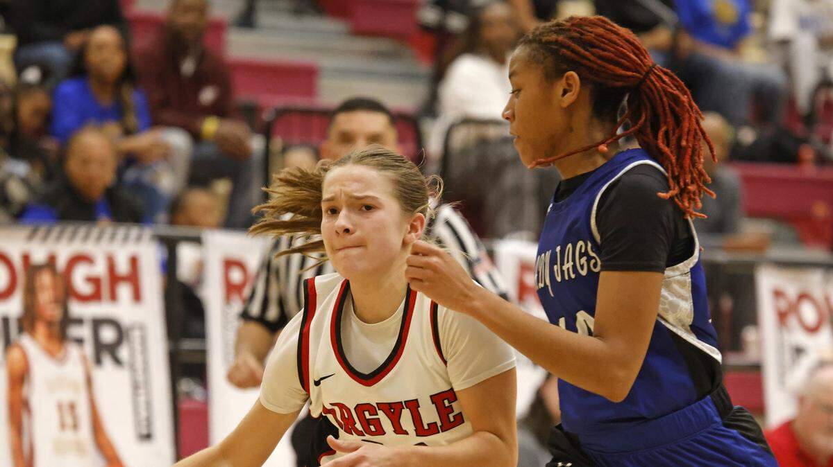Argyle guard Lexi Ehrhardt (20) drives hard to the net defended by Mansfield Summit guard Kyleigh Smith (10) during the second half of a UIL Class 5A DII girls playoff basketball game at Saginaw High School in Saginaw, Texas, Thursday Feb. 19, 2026.