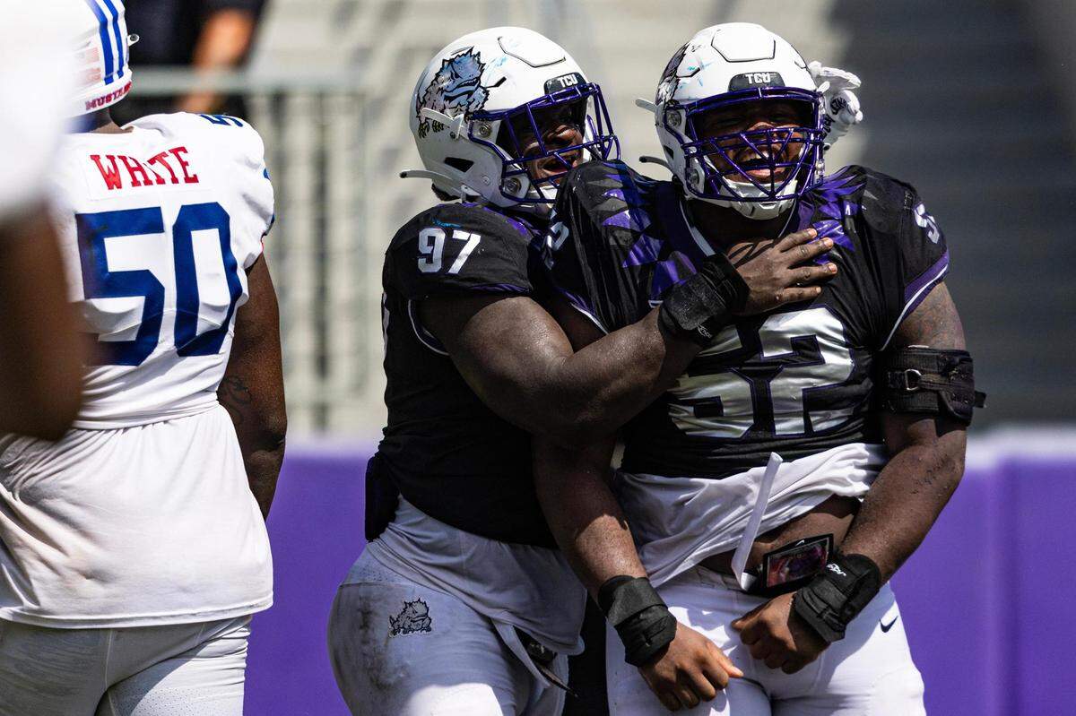 TCU defensive linemen Paul Oyewale (97) and Damonic Williams (52) celebrate after getting a sack to seal the game in the fourth quarter against SMU at Amon G. Carter Stadium in Fort Worth on Saturday.